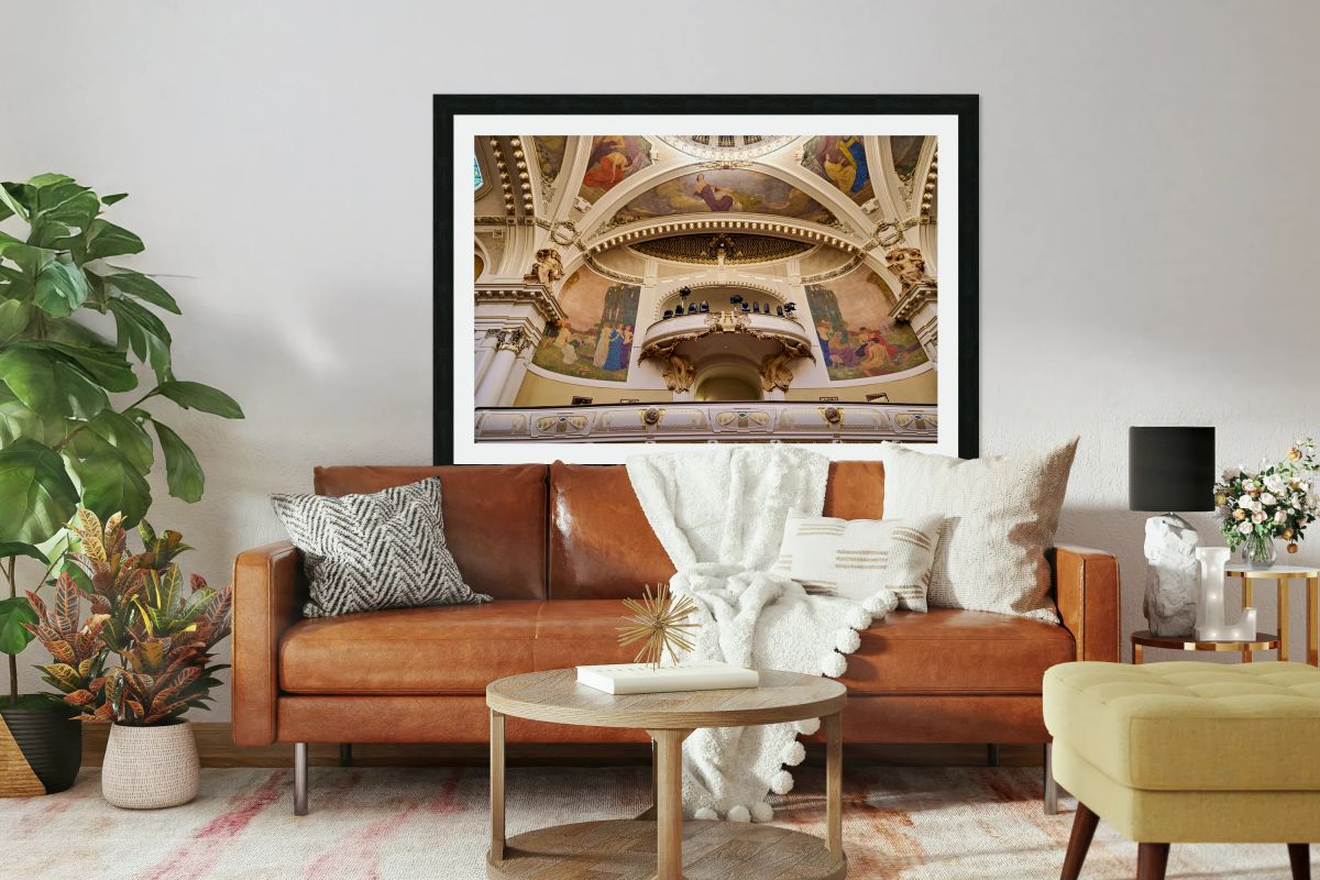 Ornate theater interior with murals sculptures and balcony.