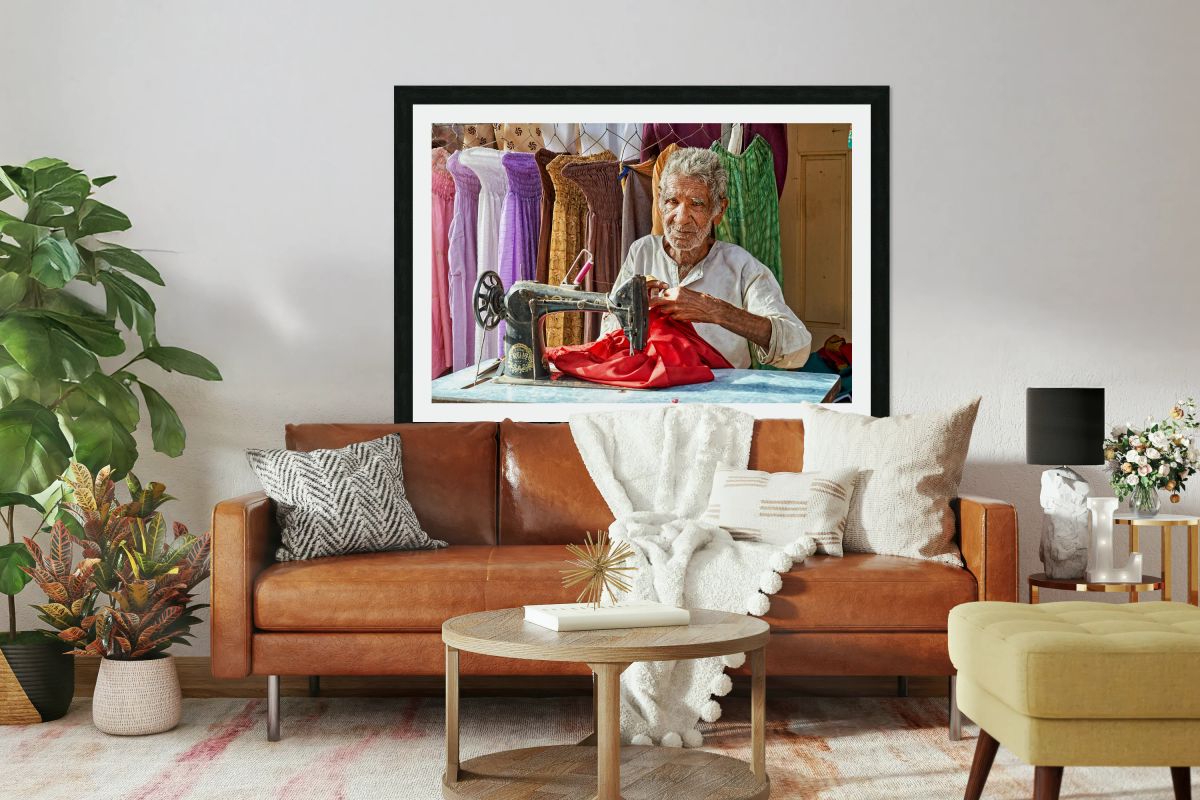Elder man sewing red fabric in Jaisalmer Rajasthan India