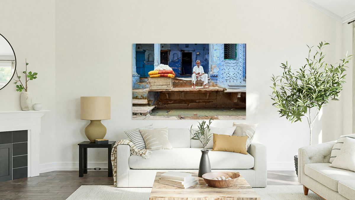 Portrait of an old man sitting by a blue building in Bundi Raja