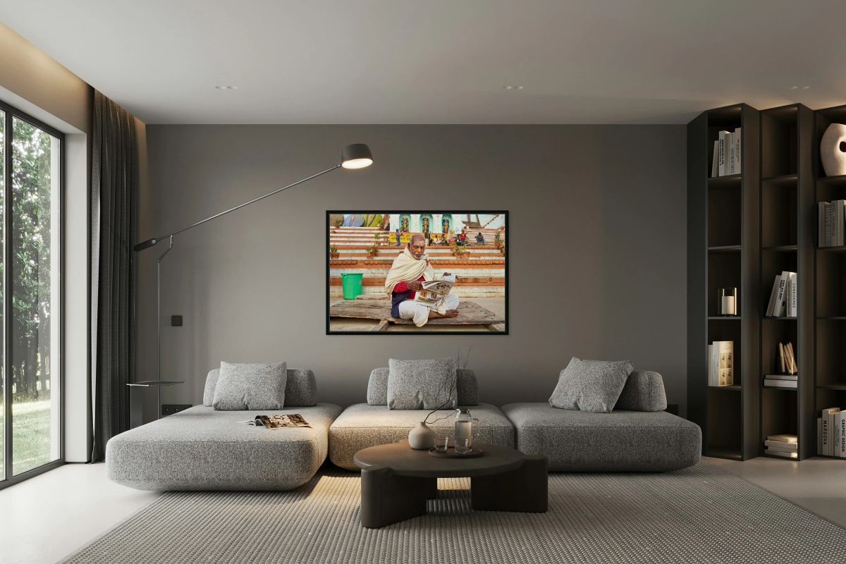 Man reads newspaper by river in Varanasi India