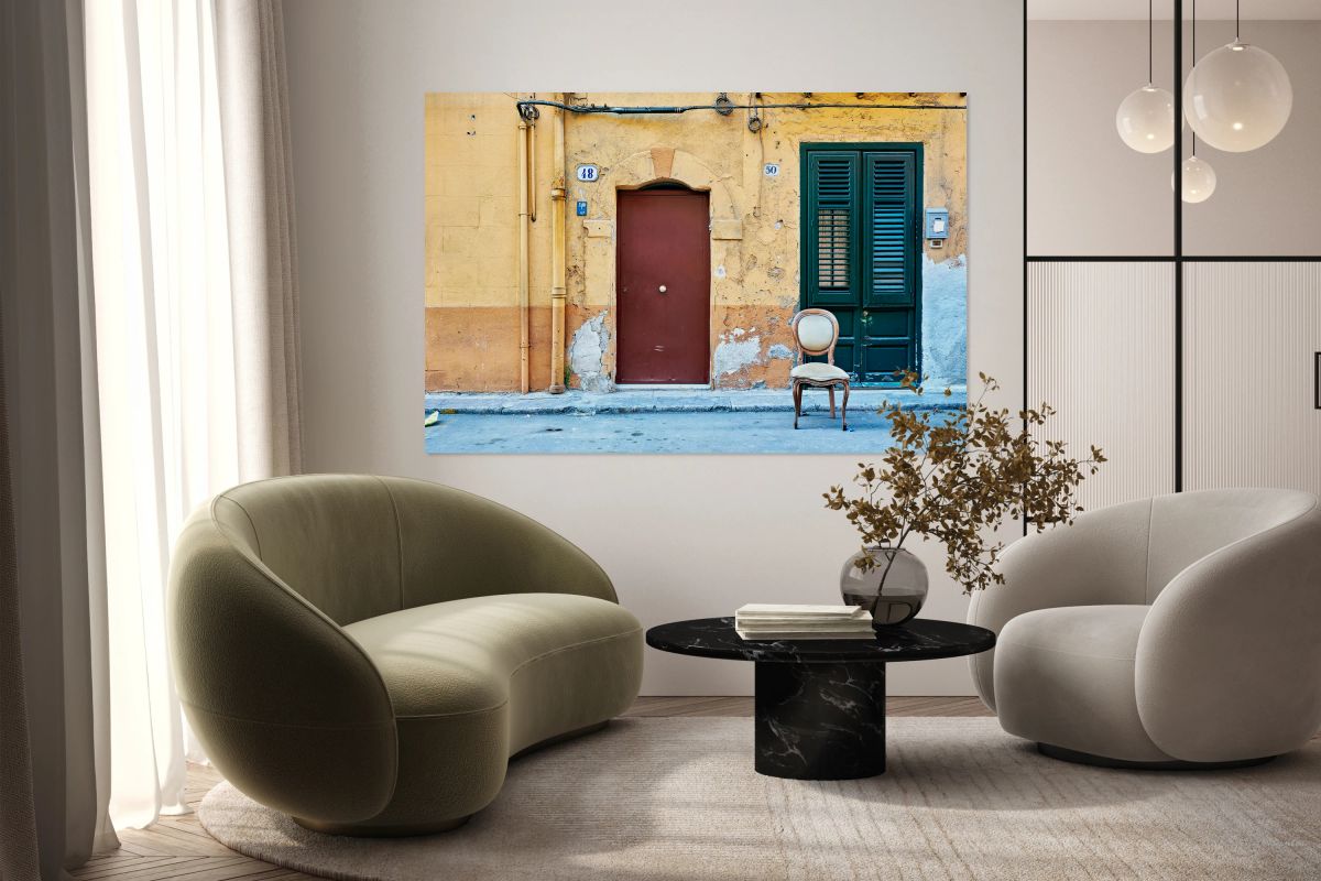 Empty chair in front of colorful building in Palermo Sicily Ital