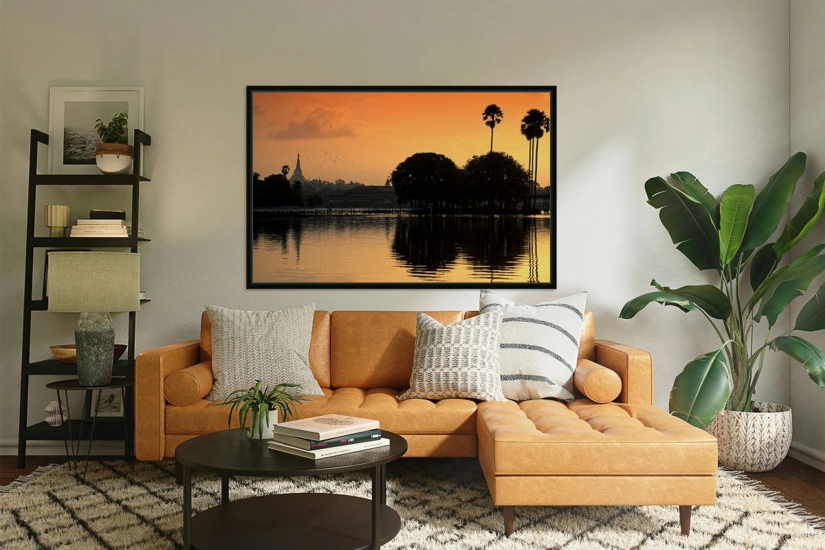 Sunset over the water in Yangon with palm trees and buildings