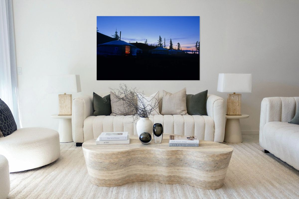 Yurts at sunset in Mongolia with pine trees and mountains in vie
