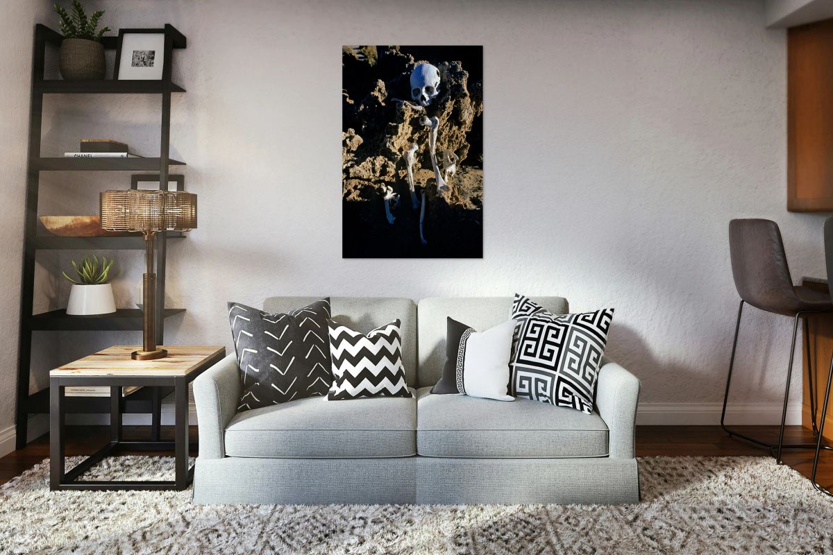 Human skeleton partially buried in rocky terrain.