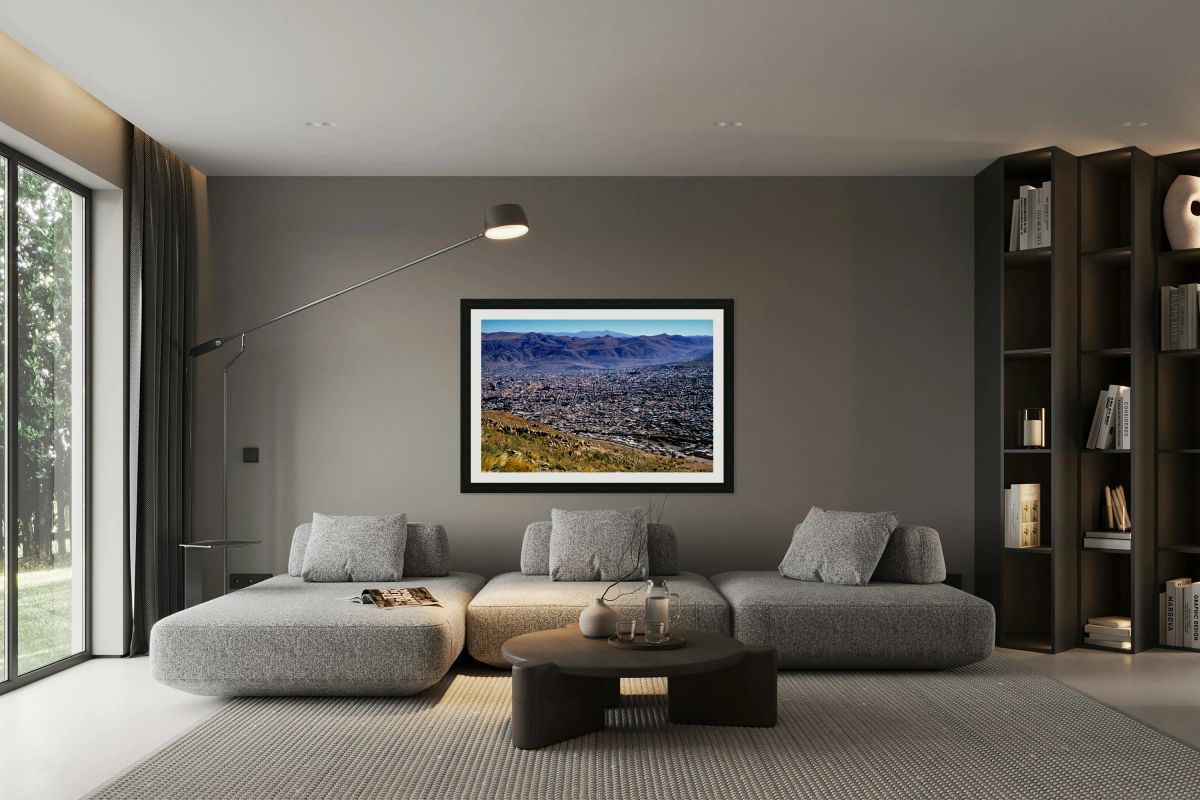 Panoramic view of a sprawling city in a mountain valley.