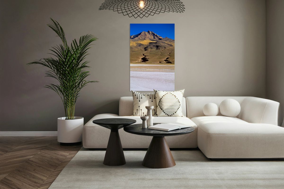 Mountain overlooks vast salt flat under clear blue sky.