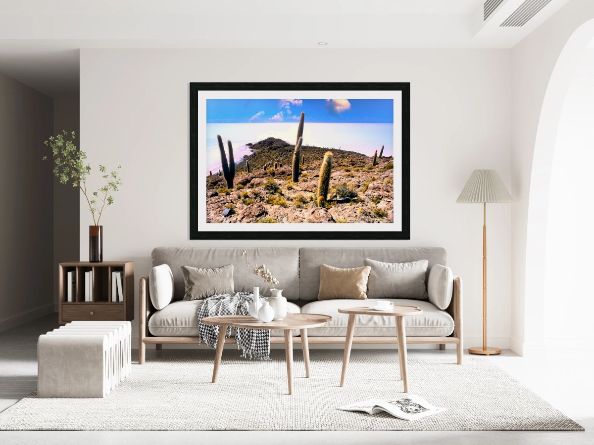 Cactus island in a vast white salt flat under blue sky.