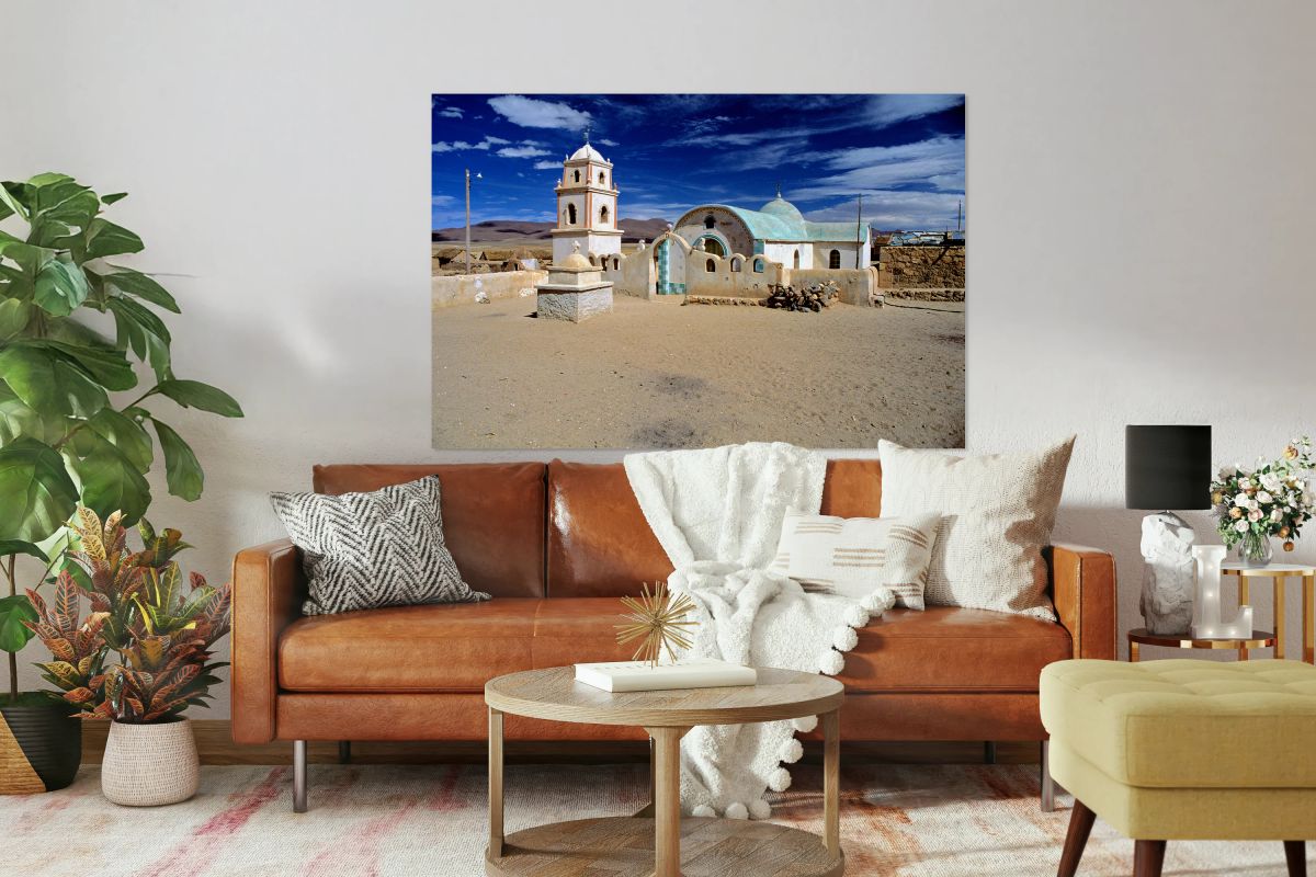 Remote desert church with bell tower under a dramatic sky.
