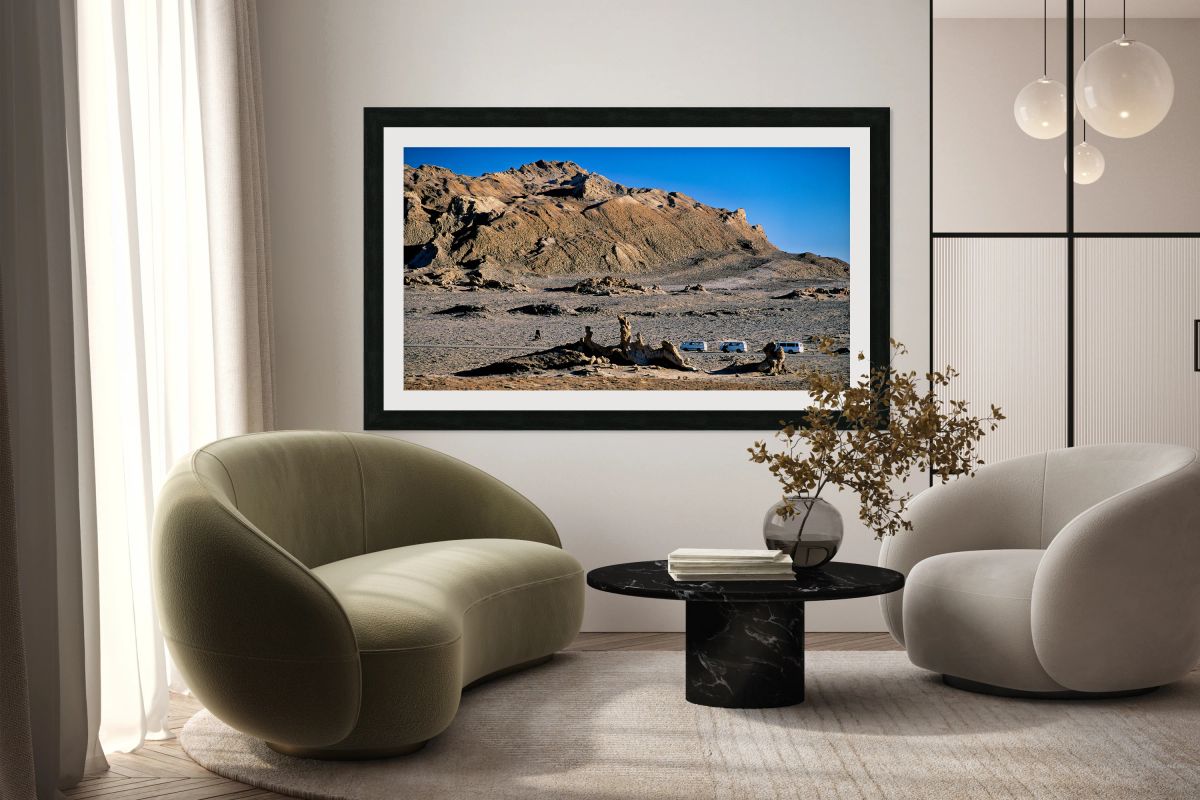 Arid mountain landscape with vans on a desert road.