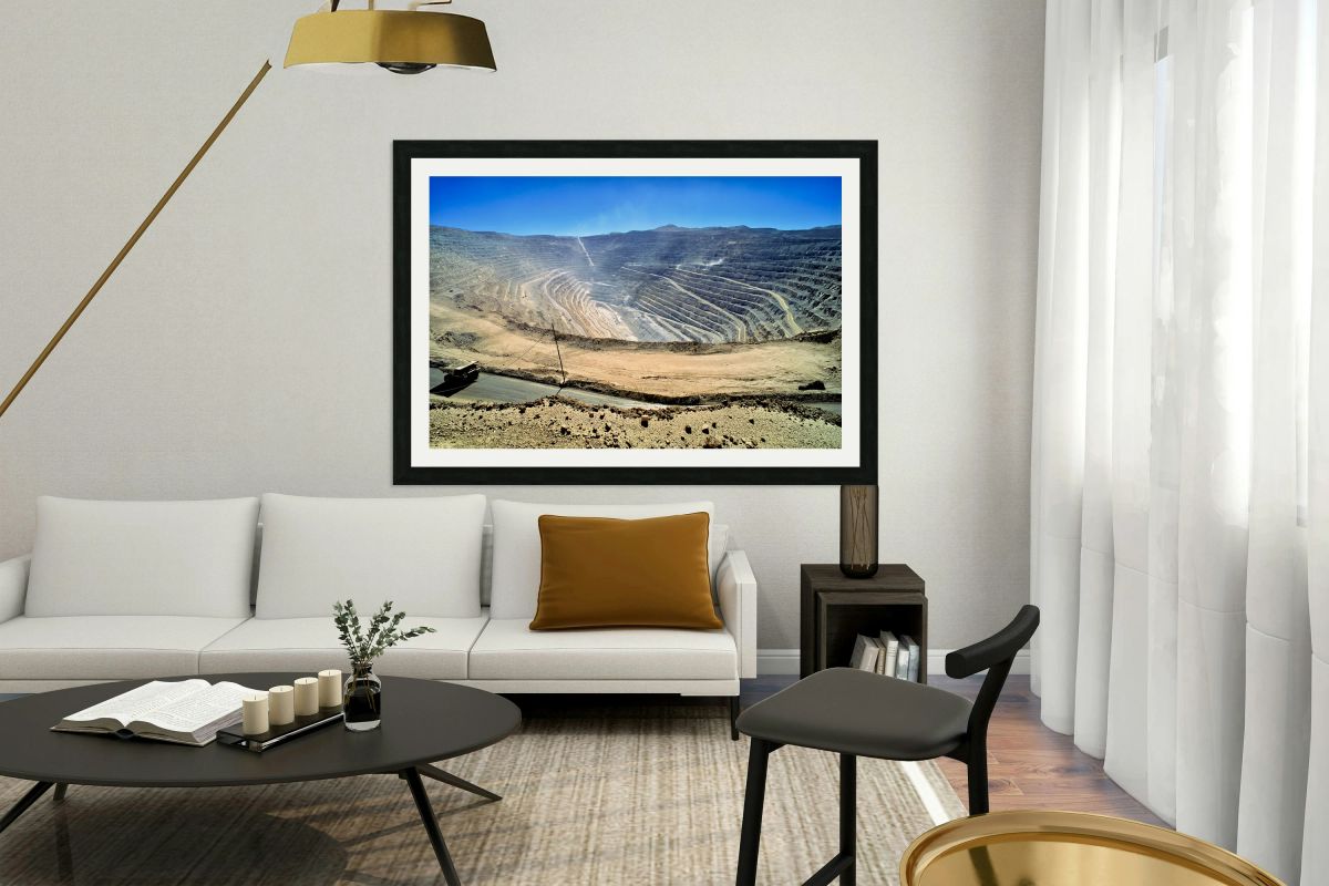 Vast open pit mine with terraced walls and haul truck.