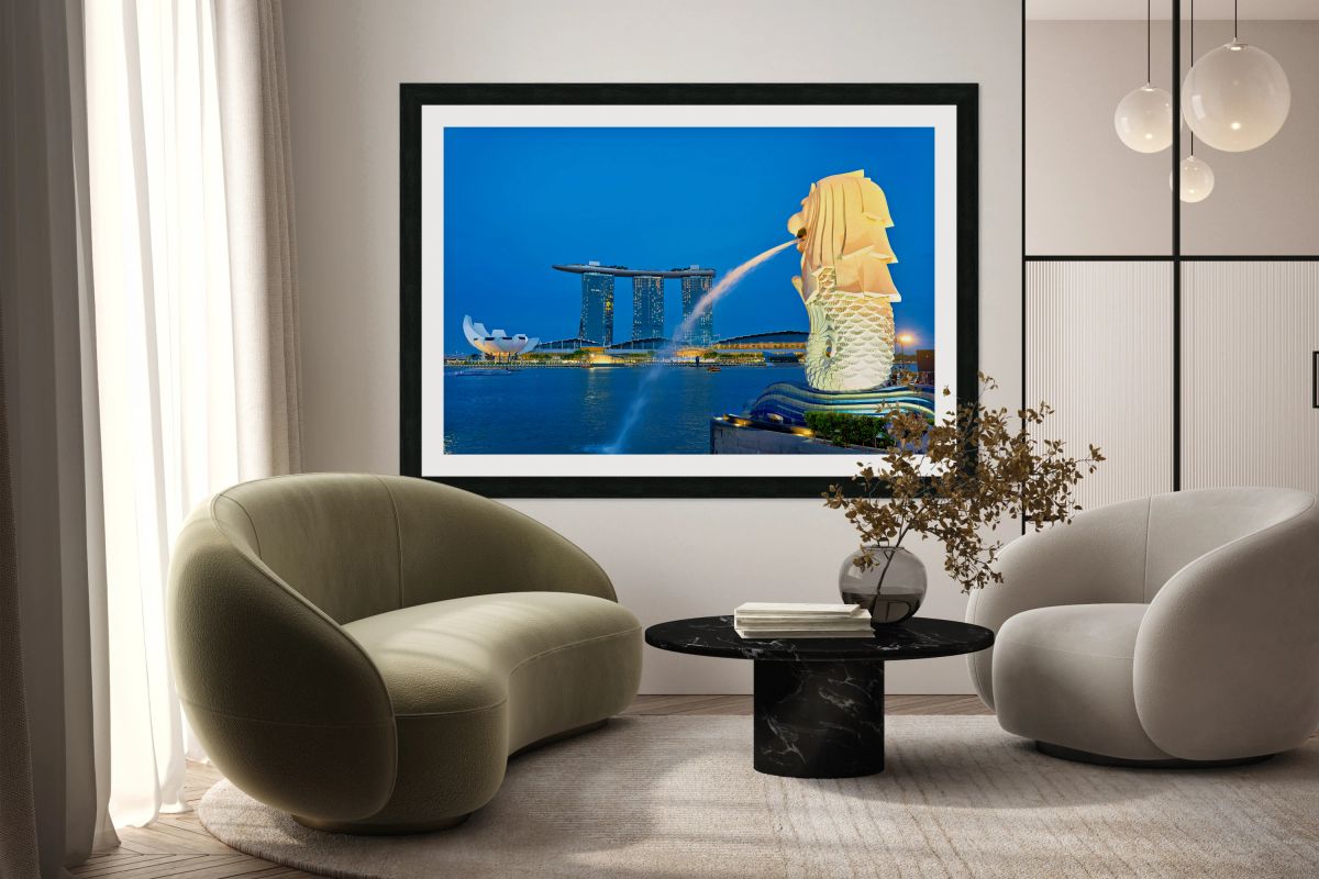 Visitors watch the Merlion fountain at Marina Bay during sunset