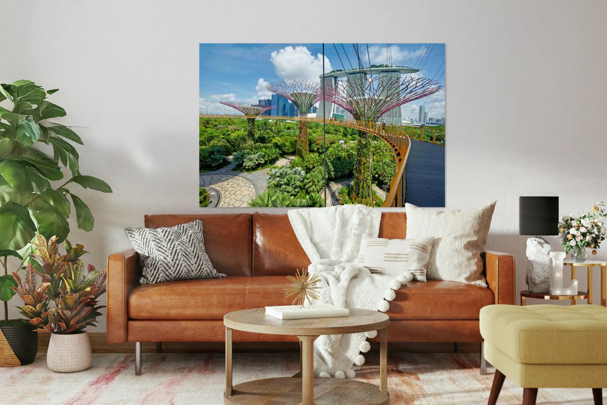 People walk on bridge to Supertree Grove with city in view