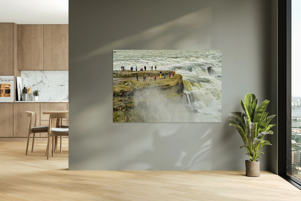 Visitors admire Gullfoss waterfall in Iceland on a cloudy day