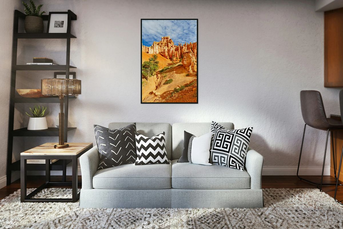 Visitors walk through Queens Garden in Bryce Canyon National Park. Tall rock formations and clouds fill the sky during daylight.