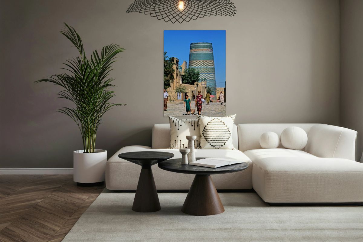 Women and children walk by the tall tower in Khiva Uzbekistan