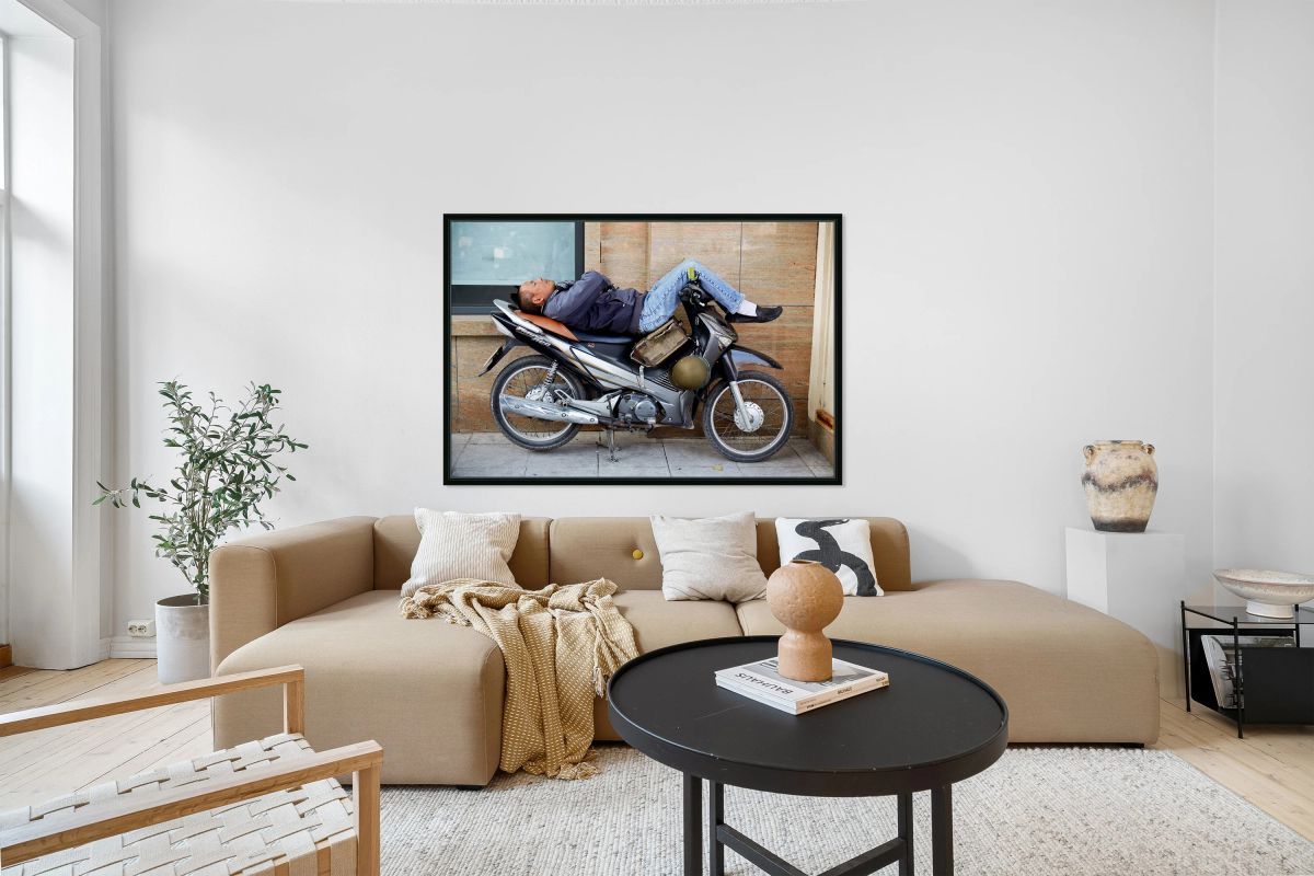 Man resting on motorcycle in Hanoi during the day