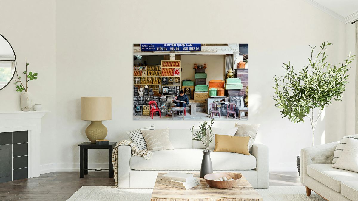 Craftsman works at a shop in Hanoi Vietnam while reading