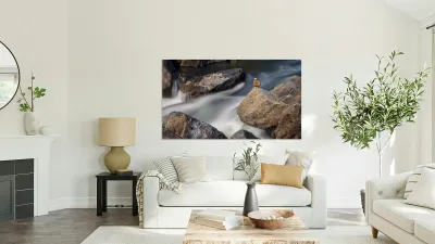 Pebbles balanced on rocks in raging river illustrating resilienc Reproduction