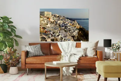 Santorinis white buildings cascade down cliff to the sea. Reproduction