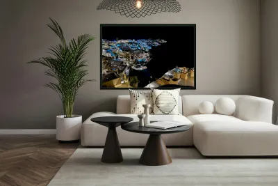 Illuminated cliffside town at night couple enjoying dinner. Reproduction