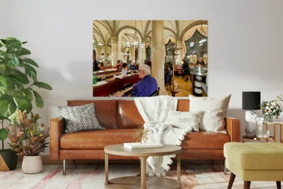 Man playing piano in an ornate bustling cafe. Reproduction