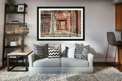 Ancient temple wall with intricate reddish stone carvings and co Reproduction