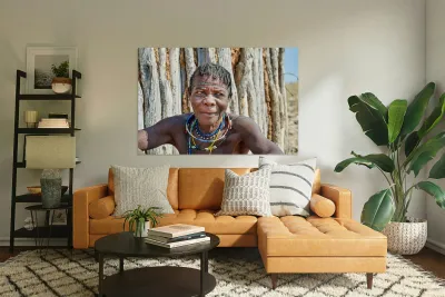 Old woman of Zemba Bantu ethnic group sits near wooden wall in N Reproduction