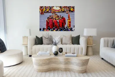 Monks in red robes gathered around a golden statue. Reproduction