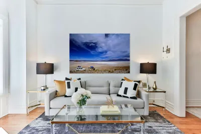 Vehicles traverse a vast arid salt flat landscape. Reproduction