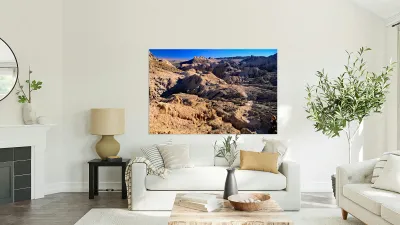 Hikers traverse a vast arid rocky desert landscape. Reproduction